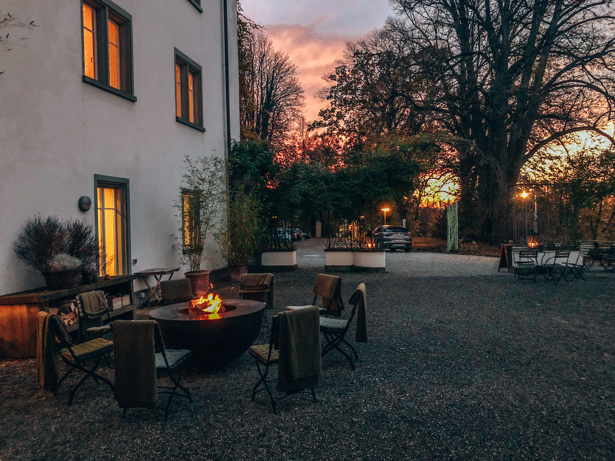 Gemütlicher Außenbereich mit Lagerfeuer bei Sonnenuntergang