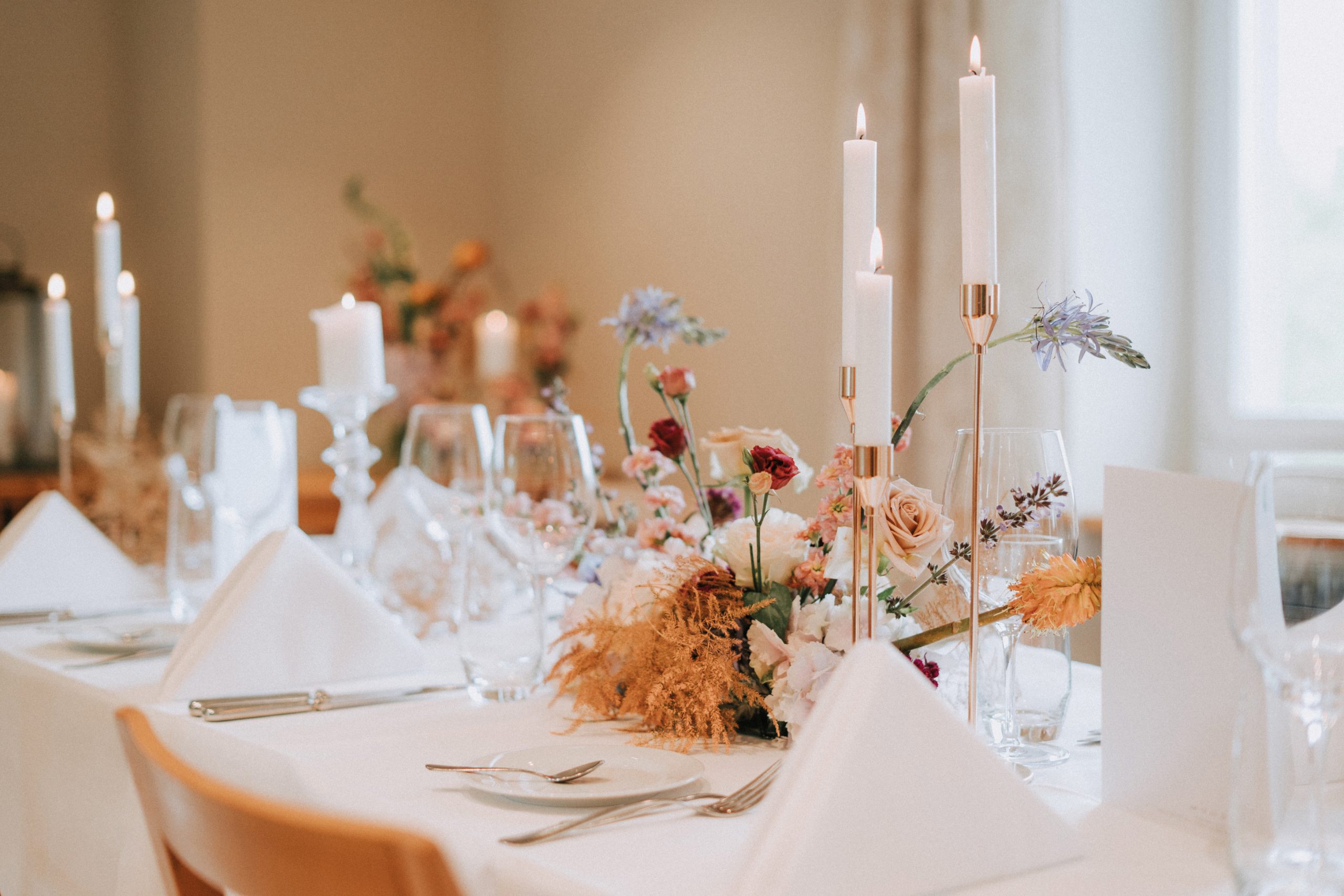 Elegantly gedeckter Tisch mit Kerzen und Blumen